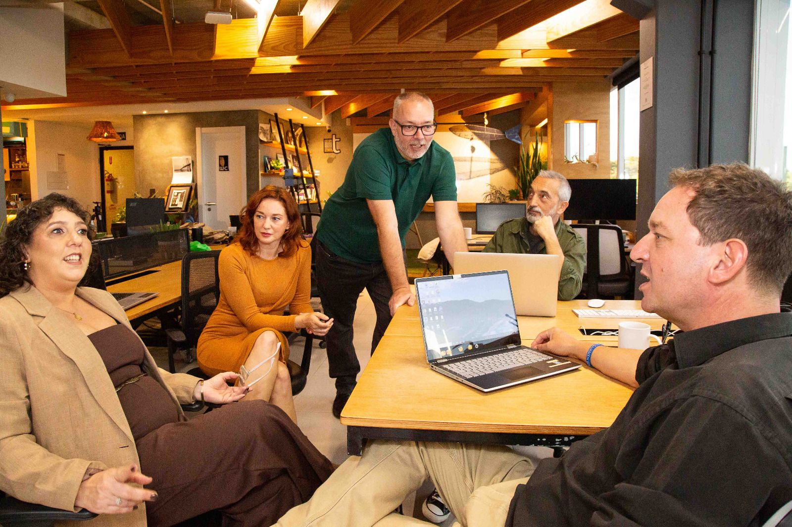 The Gateway Mercosur team talking around a table in their open-plan office in Florianópolis